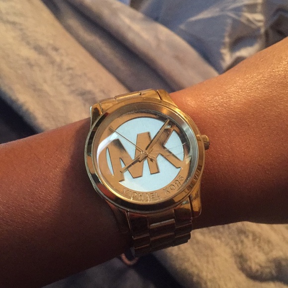A gold Michelle Kors watch with the MK symbol. - Picture 1 of 1
